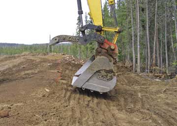 Figure 10.12 - An alternative form of imprinting road cuts and fills that does not compact soils is welding angle iron onto the bucket of an excavator. As the excavator pulls topsoil into place and contours the slope, it presses the face of the bucket into the soil surface to form surface imprints.