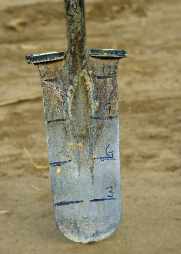 Figure 5.17 - A simple, qualitative method of determining compacted layers is to mark the face of a long shovel with a ruler. By pushing the shovel in the ground with the entire body weight and observing the distance the shovel penetrated can give a measure of the depth to a compacted layer.